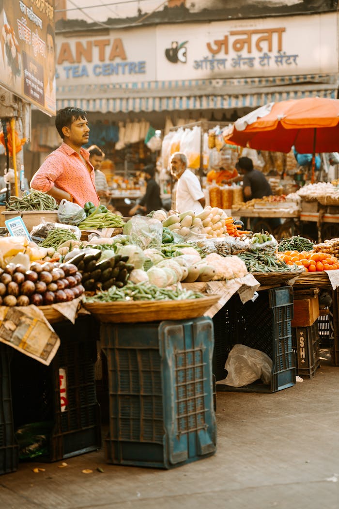 About Bustling Indian market with colorful vegetable stalls and busy vendors.
